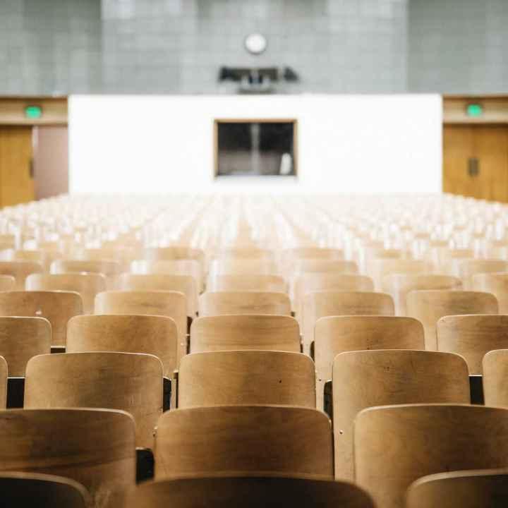 Photo of an empty auditorium with wooden seats